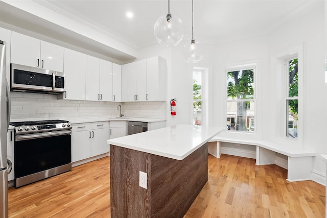 52 Brinkerhoff St, Jersey City, NJ 07304 - kitchen featuring stainless steel appliances, ornamental molding, light countertops, light wood-style flooring, and backsplash