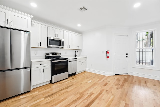 52 Brinkerhoff St, Jersey City, NJ 07304 - kitchen with stainless steel appliances, light countertops, light wood finished floors, recessed lighting, and white cabinetry