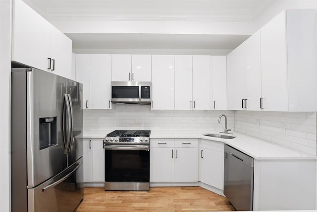 52 Brinkerhoff St, Jersey City, NJ 07304 - kitchen featuring appliances with stainless steel finishes, crown molding, light countertops, light wood-style flooring, and decorative backsplash