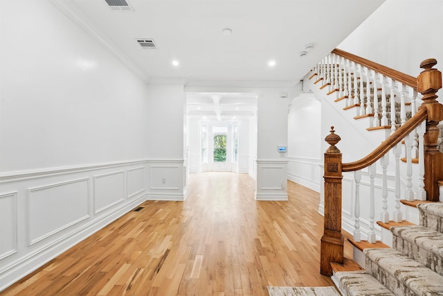 52 Brinkerhoff St, Jersey City, NJ 07304 - foyer featuring a decorative wall, light wood-style flooring, stairway, ornamental molding, and a wainscoted wall