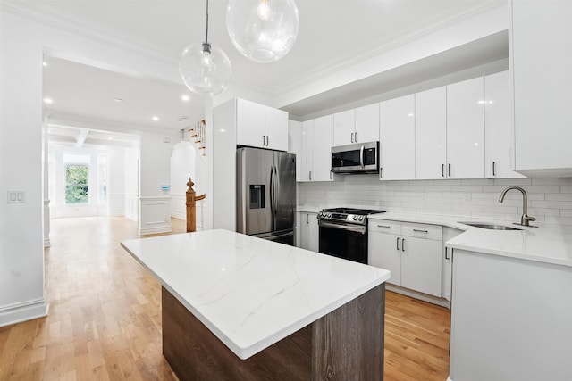 52 Brinkerhoff St, Jersey City, NJ 07304 - kitchen featuring appliances with stainless steel finishes, crown molding, light wood-style flooring, a kitchen island, and tasteful backsplash