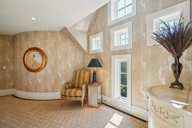 sitting room with a high ceiling and baseboards