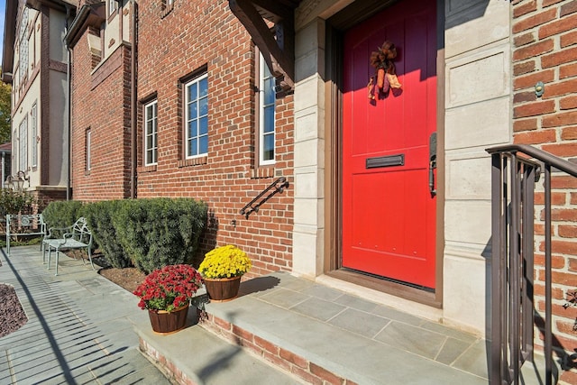 view of exterior entry featuring brick siding