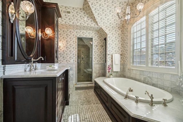 bathroom with a wainscoted wall, tile walls, a shower stall, vanity, and wallpapered walls