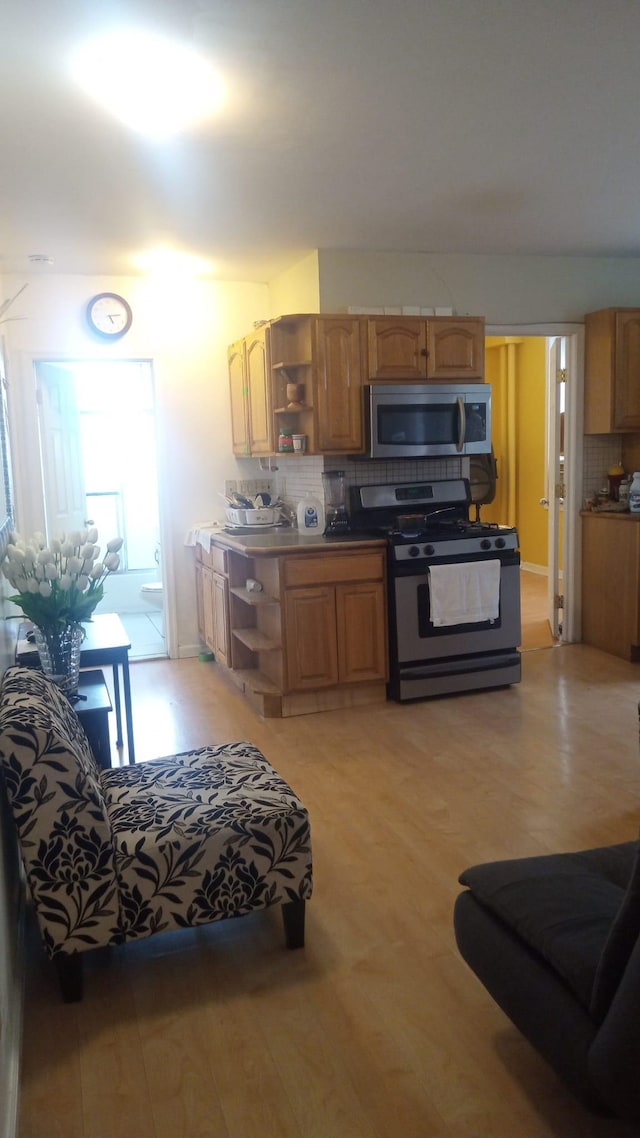 201 45th St Unit E4, Union City, NJ 07087 - kitchen with stainless steel appliances, open shelves, tasteful backsplash, and light wood-type flooring