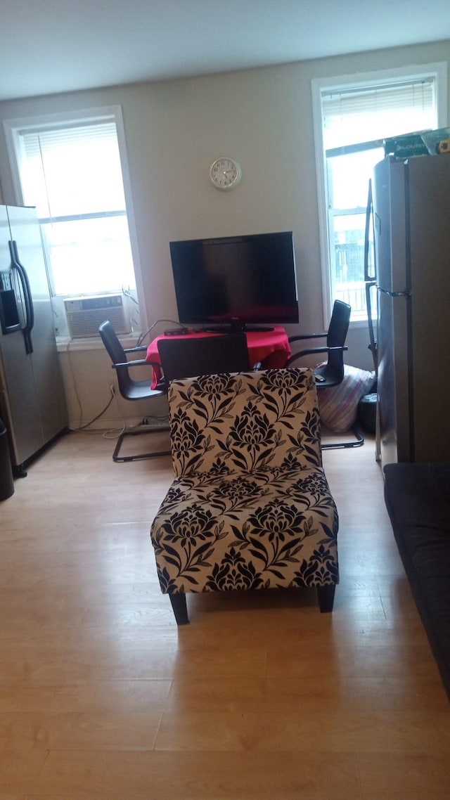 living room with cooling unit and light hardwood / wood-style flooring