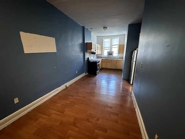 hallway with baseboards and wood finished floors