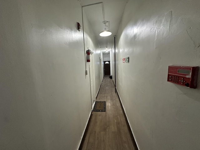 corridor featuring wood finished floors and baseboards