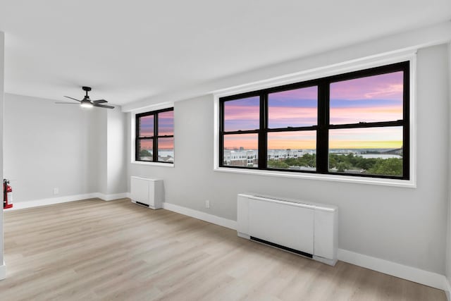 1225 Kennedy Blvd Unit 5A, Bayonne, NJ 07002 - spare room featuring light wood-type flooring, ceiling fan, baseboards, and radiator heating unit