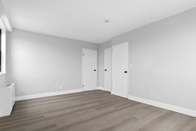 1225 Kennedy Blvd Unit 5A, Bayonne, NJ 07002 - unfurnished bedroom with radiator heating unit, wood finished floors, and baseboards