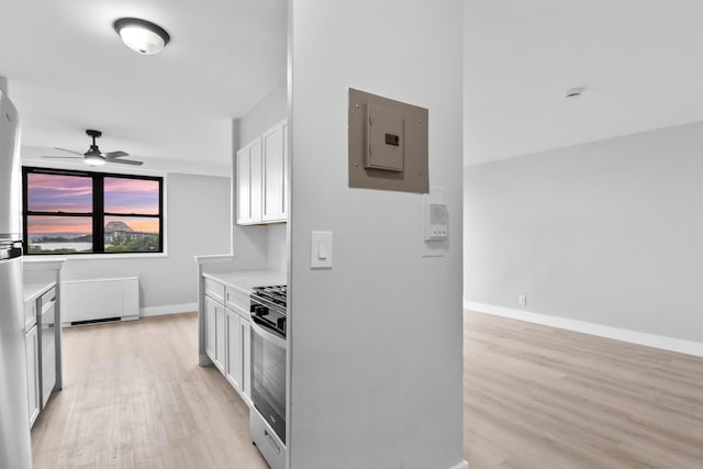 1225 Kennedy Blvd Unit 5A, Bayonne, NJ 07002 - kitchen with electric panel, stainless steel range with gas stovetop, ceiling fan, light wood-style flooring, and light countertops