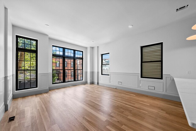 166 New York Ave, Jersey City, NJ 07307 - spare room featuring light wood finished floors, wainscoting, a decorative wall, and recessed lighting