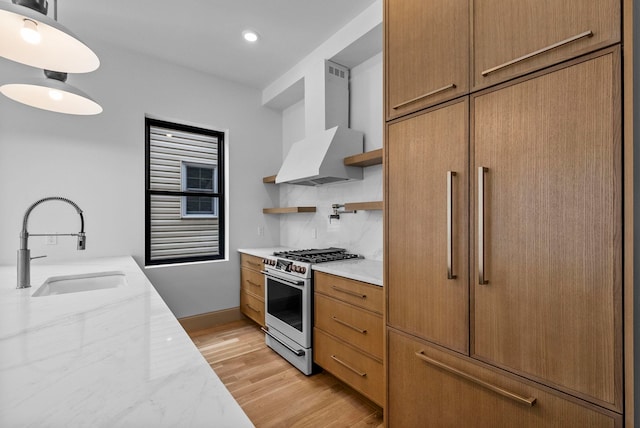 166 New York Ave, Jersey City, NJ 07307 - kitchen featuring wall chimney range hood, gas stove, open shelves, backsplash, and light wood-style floors