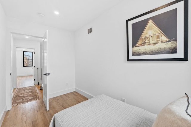 bedroom featuring recessed lighting, wood finished floors, visible vents, and baseboards