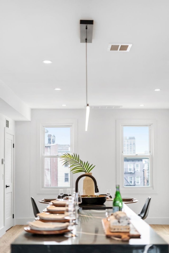 dining room with baseboards, visible vents, light wood-style flooring, and recessed lighting