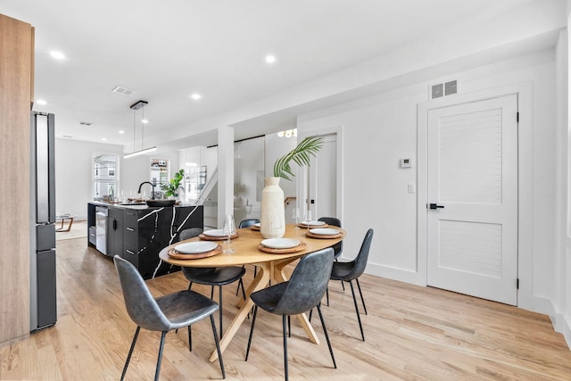 dining area with light wood-style floors, recessed lighting, visible vents, and baseboards