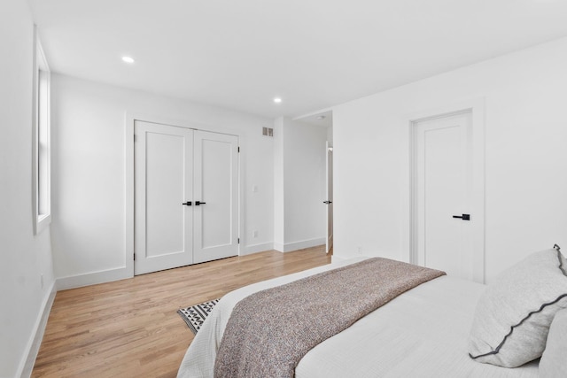 bedroom with recessed lighting, visible vents, baseboards, a closet, and light wood finished floors