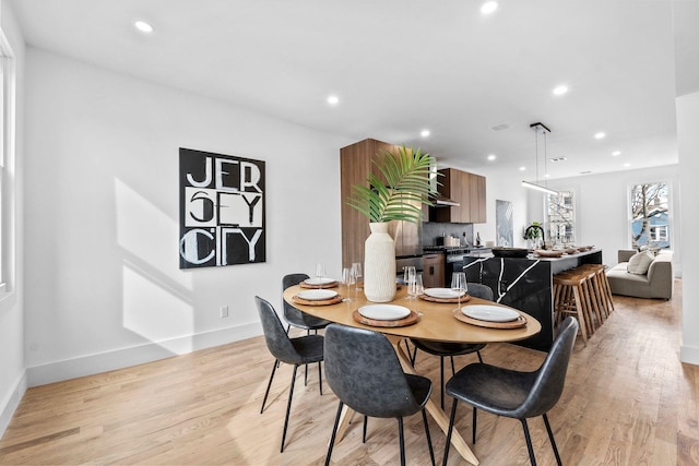 dining room featuring baseboards, light wood-style flooring, and recessed lighting