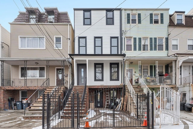 townhome / multi-family property featuring a fenced front yard, a gate, and stairway