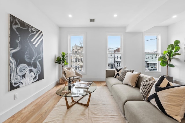 living room with light wood finished floors, baseboards, visible vents, and recessed lighting