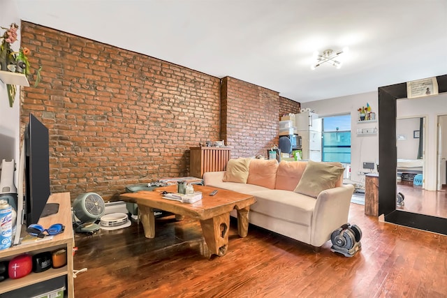 living room featuring hardwood / wood-style floors and brick wall