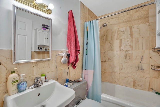 full bathroom with shower / tub combo with curtain, sink, tile walls, and toilet