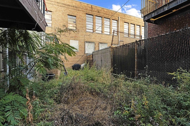 exterior space featuring brick siding and fence