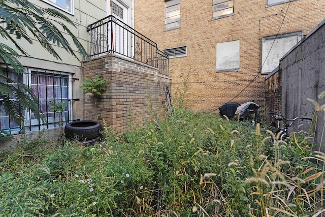 view of side of home featuring cooling unit and brick siding