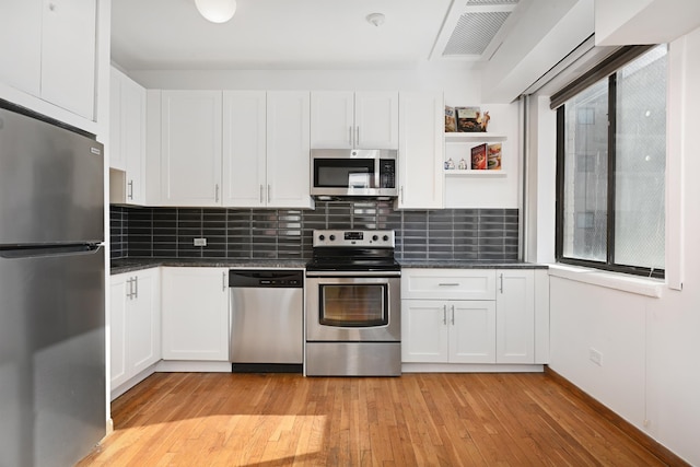 kitchen with light hardwood / wood-style flooring, white cabinets, and stainless steel appliances