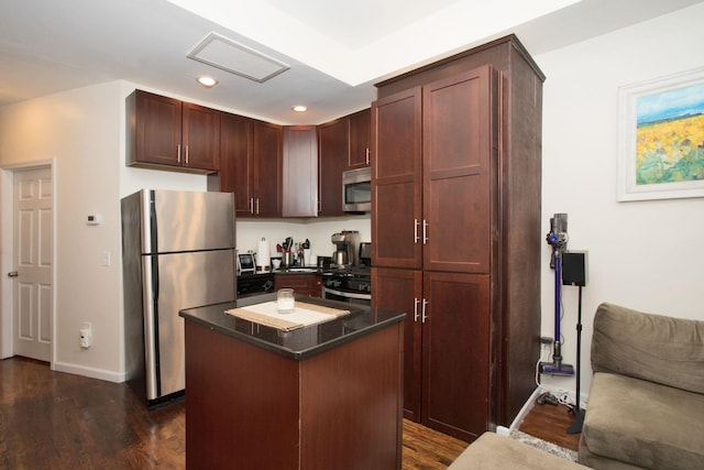 kitchen with appliances with stainless steel finishes, a center island, and dark wood-type flooring