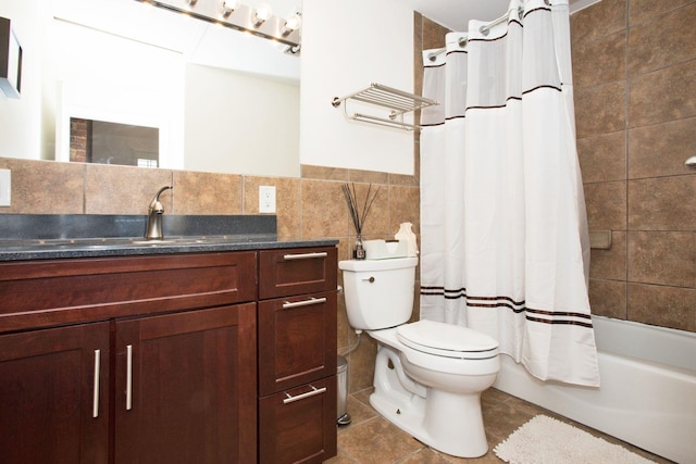 full bathroom featuring tile patterned floors, vanity, shower / bath combo with shower curtain, tile walls, and toilet