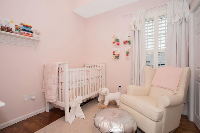 bedroom featuring dark hardwood / wood-style flooring and a crib