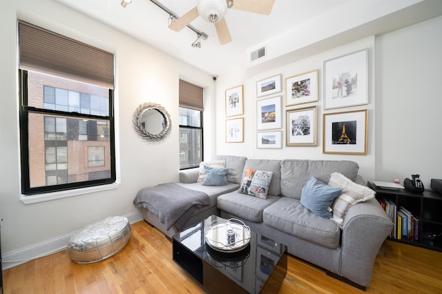 living room with ceiling fan, hardwood / wood-style floors, and rail lighting