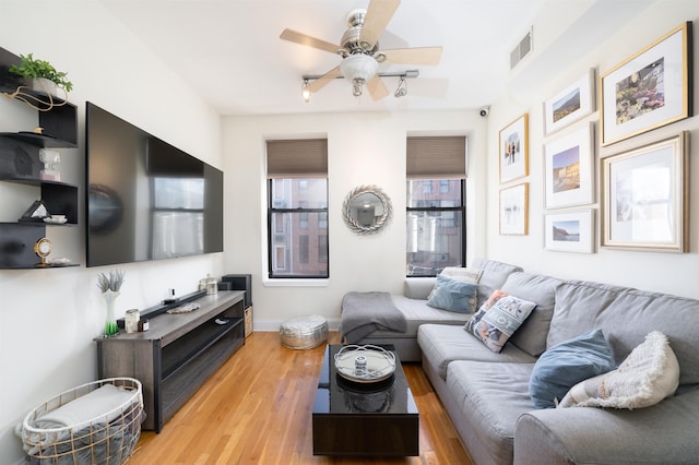 living room with light hardwood / wood-style flooring and ceiling fan