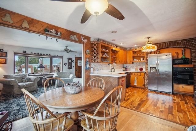 dining space with light wood finished floors and a ceiling fan