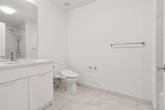 bathroom with vanity, toilet, and tiled shower