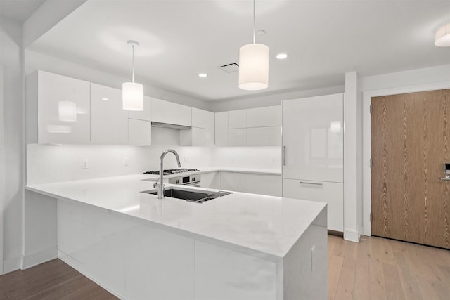 kitchen with white cabinetry, pendant lighting, and kitchen peninsula