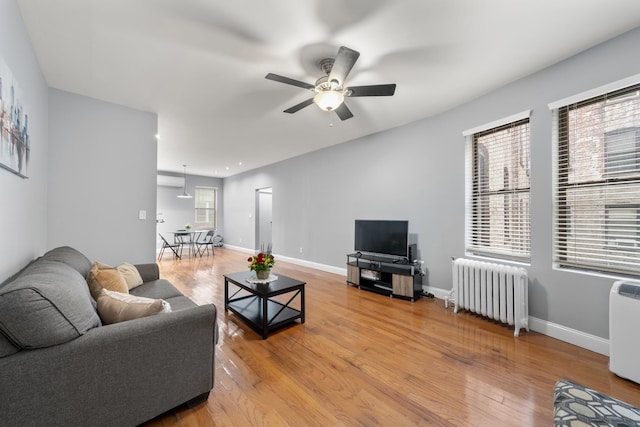 living room with radiator, ceiling fan, and hardwood / wood-style floors