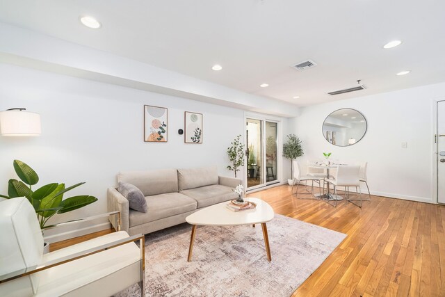 living area with light wood finished floors, recessed lighting, and baseboards