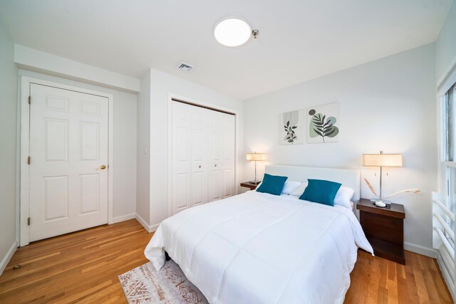 bedroom featuring wood finished floors, a closet, and baseboards