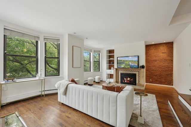 48 W Hamilton Pl Unit 5, Jersey City, NJ 07302 - living area featuring a glass covered fireplace, wood finished floors, baseboard heating, and built in features