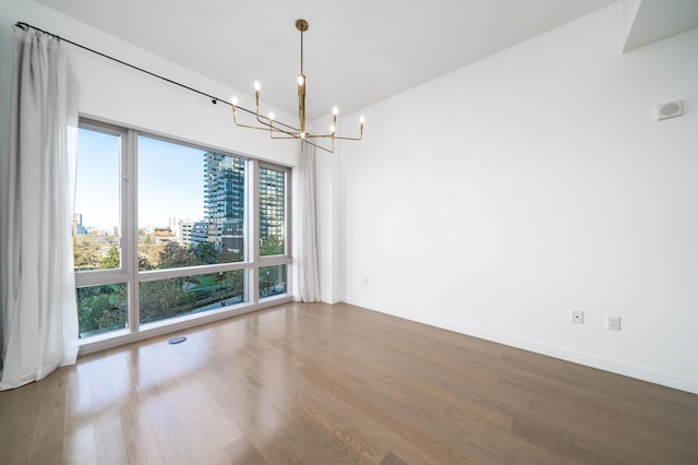 unfurnished dining area with wood-type flooring and a chandelier