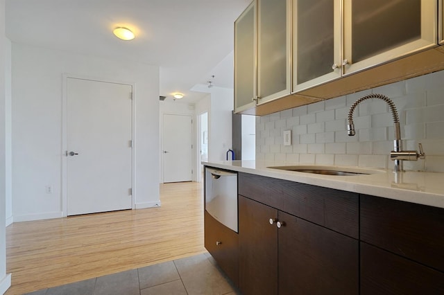 25 Mcwilliams Pl Unit 402, Jersey City, NJ 07302 - kitchen featuring light countertops, dark brown cabinetry, baseboards, and a sink
