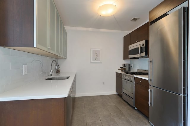 25 Mcwilliams Pl Unit 402, Jersey City, NJ 07302 - kitchen with dark tile patterned floors, decorative backsplash, a sink, light countertops, and stainless steel appliances
