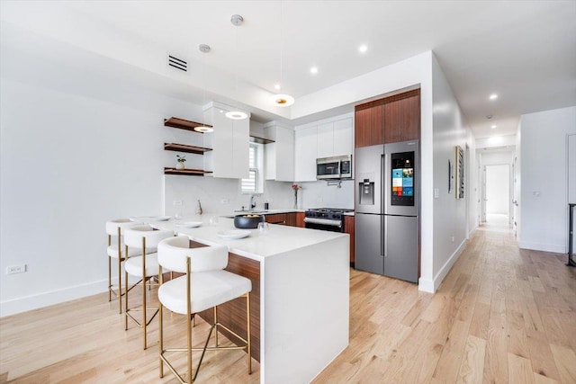 91 Pearsall Ave Unit 2, Jersey City, NJ 07305 - kitchen with a kitchen bar, visible vents, open shelves, a peninsula, and stainless steel appliances