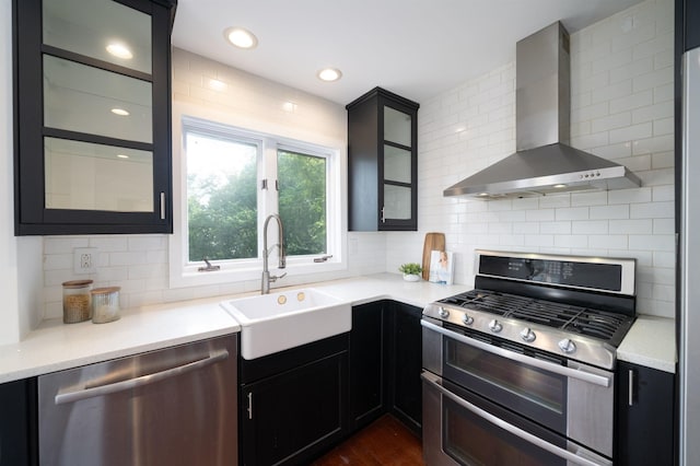 1604 74th St Unit D15, North Bergen, NJ 07047 - kitchen with appliances with stainless steel finishes, wall chimney exhaust hood, decorative backsplash, light countertops, and recessed lighting