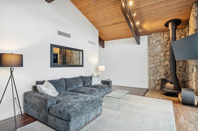 living room featuring hardwood / wood-style floors, a wood stove, lofted ceiling, and wood ceiling