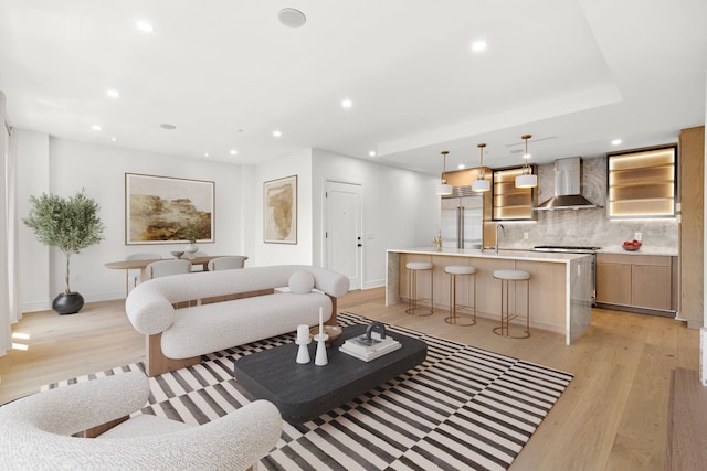 living room with baseboards, light wood-style floors, and recessed lighting