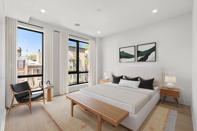 bedroom featuring light wood finished floors, baseboards, and recessed lighting