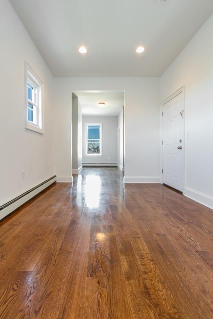 interior space featuring dark hardwood / wood-style floors and a baseboard heating unit